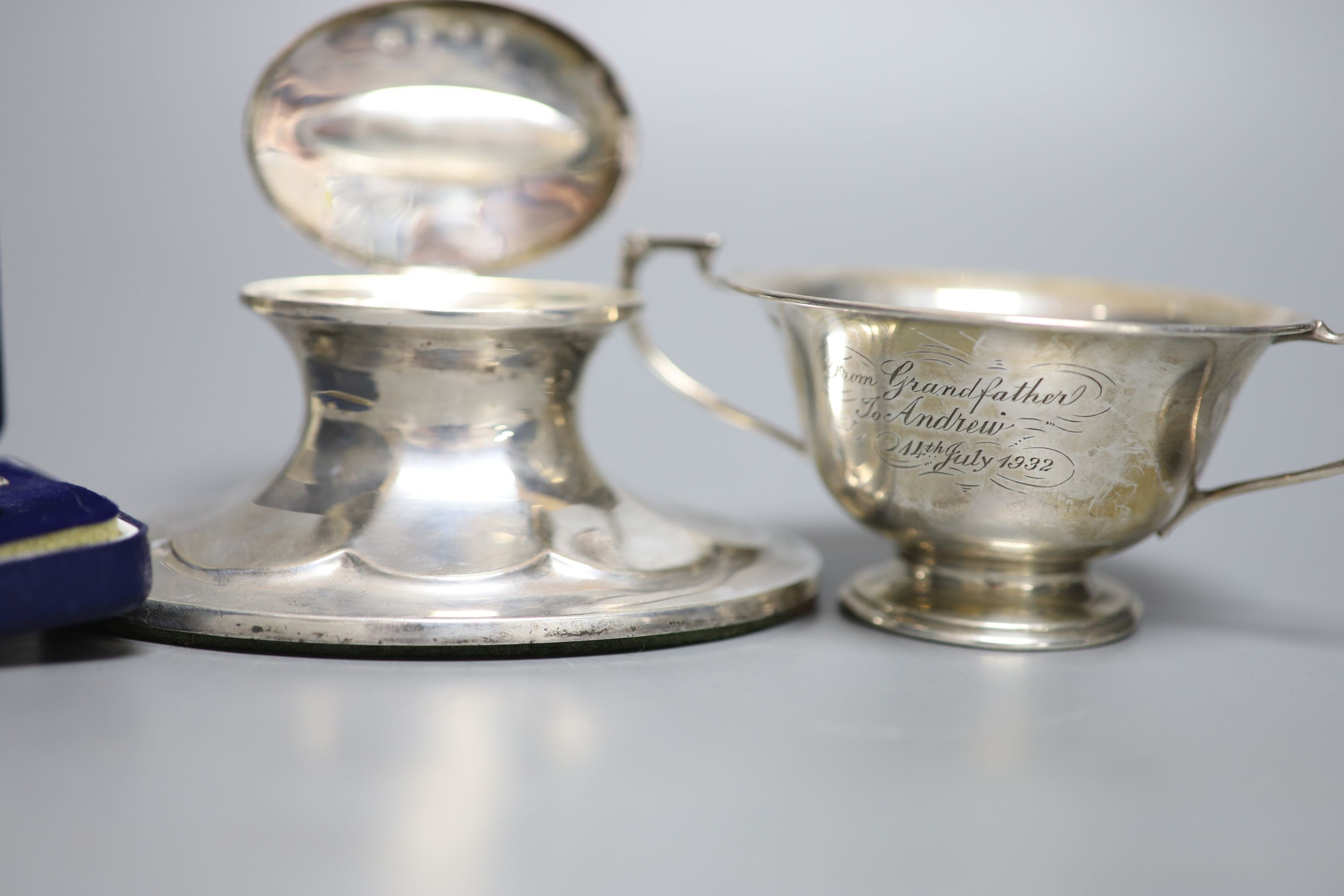 A Scottish silver mounted oval inkwell, 13.2cm, a small silver bowl, silver vesta case, silver cigarette case, two silver napkin rings and two other items.